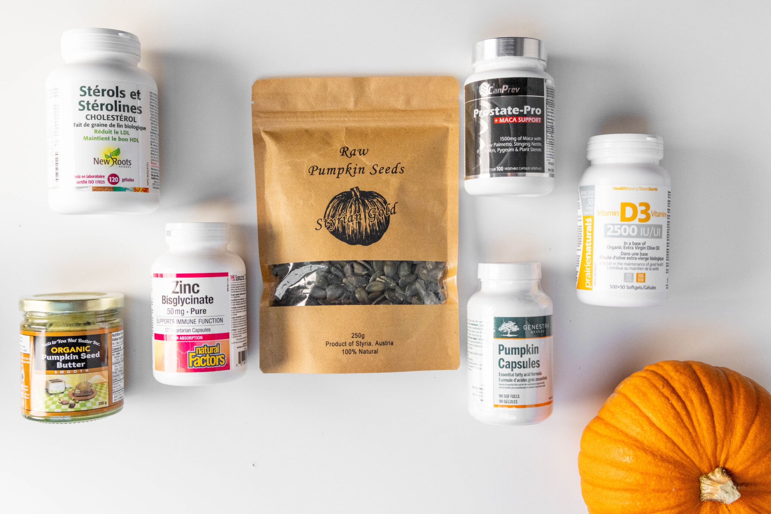 Collection of supplements and a large bag of raw pumpkin seeds alongside other natural products on a light wooden surface.